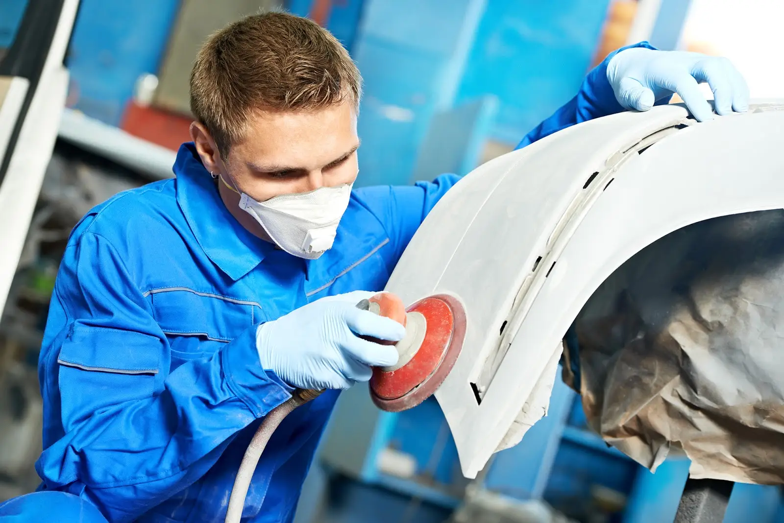 a person in a blue uniform polishing a car